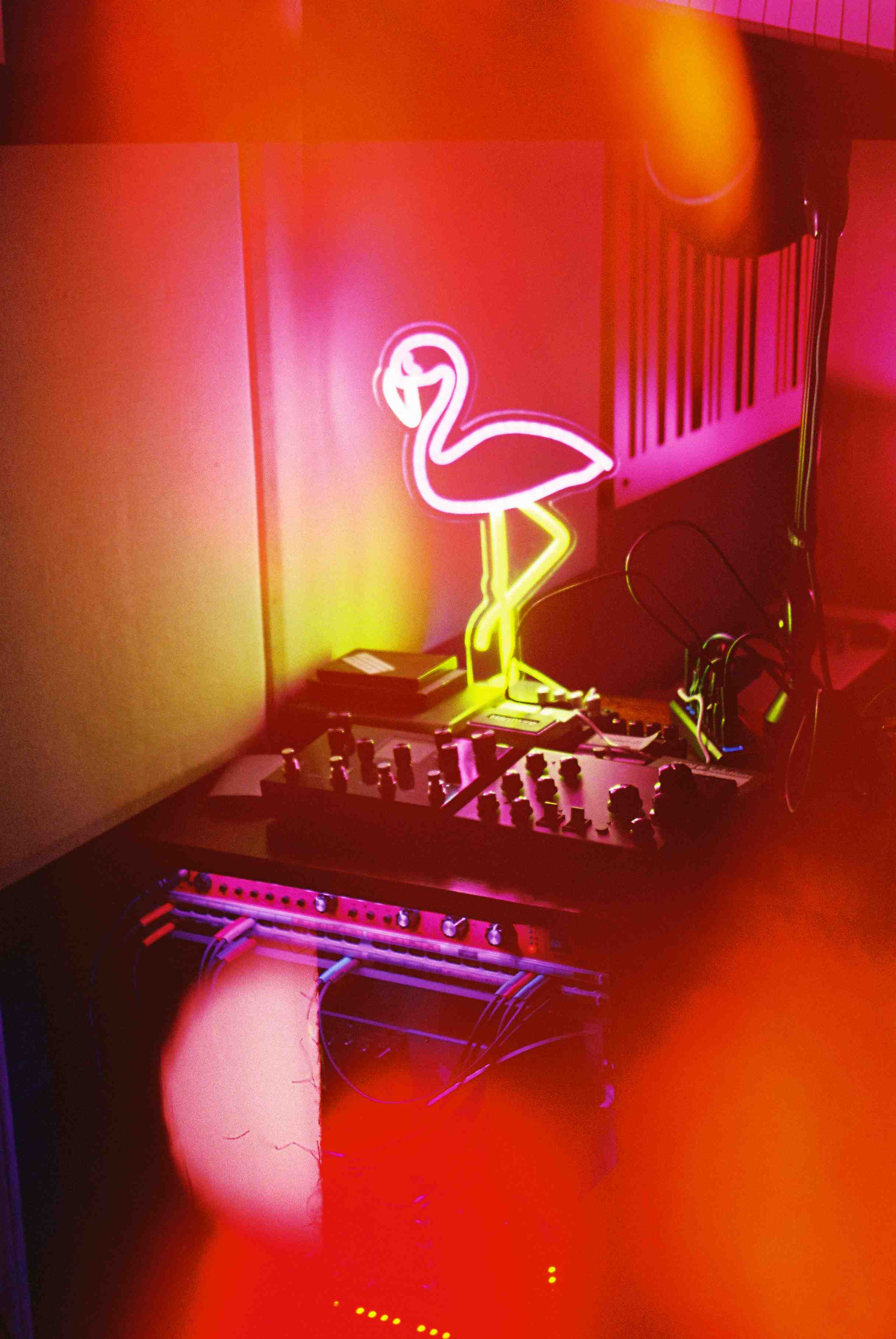 Guitar pedals illuminated by a fluorescent flamingo light